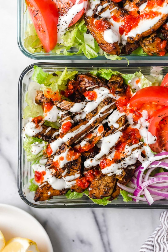 Halal Food Cart inspired chicken served over a big salad of lettuce and tomatoes drizzled with a yummy white sauce.