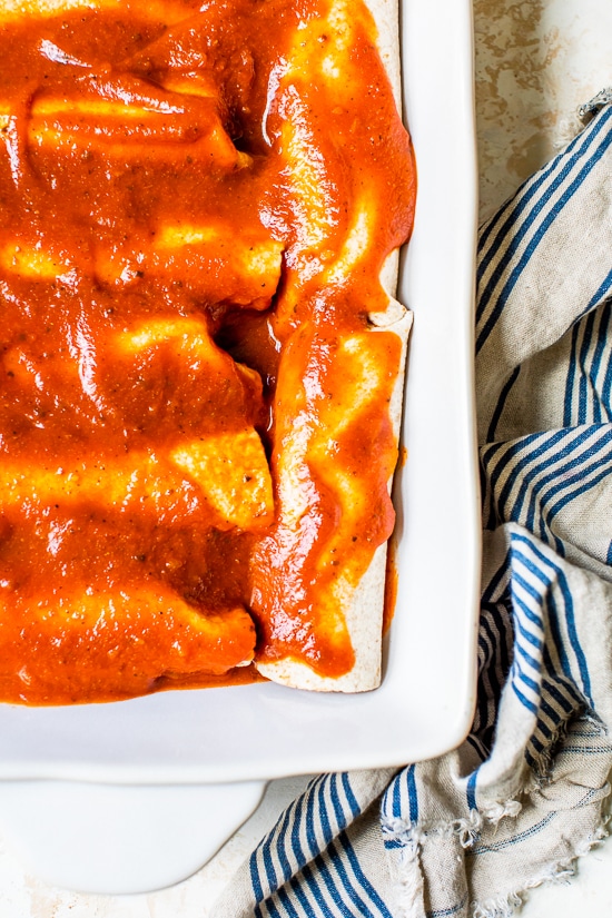 Easy vegetarian enchiladas made with butternut squash and black beans, smothered with enchilada sauce and cheese, then baked in the oven. A delicious recipe that's perfect for meatless Mondays!