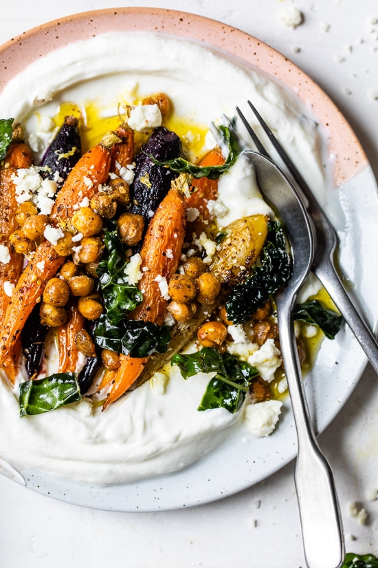 Roasted Carrots and Chickpeas seasoned with za’atar and served over Greek yogurt with lemony kale makes a wonderful side dish or meatless main!