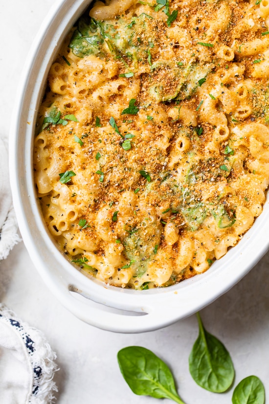 This creamy baked mac and cheese recipe is a lighter version of the classic recipe with added fiber from spinach. It's comfort food at it's finest!