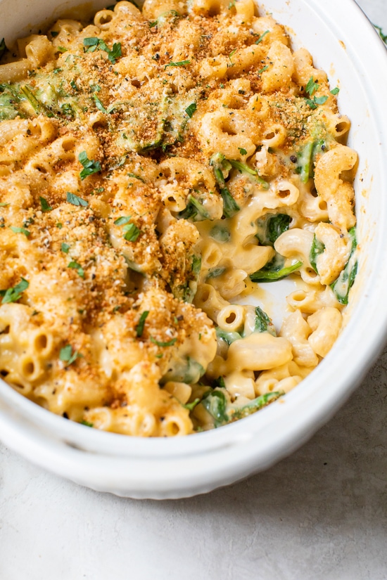 This creamy baked mac and cheese recipe is a lighter version of the classic recipe with added fiber from spinach. It's comfort food at it's finest!