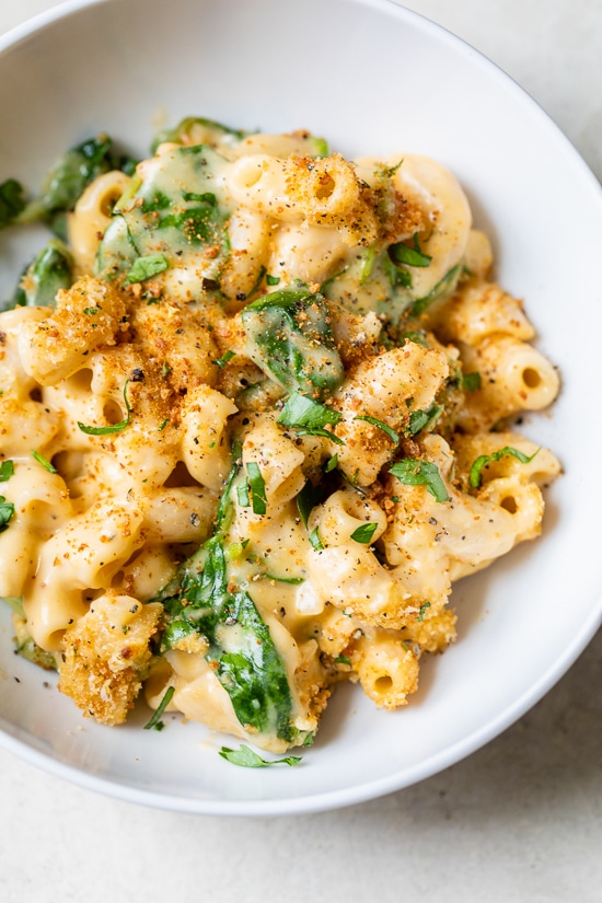 This creamy baked mac and cheese recipe is a lighter version of the classic recipe with added fiber from spinach. It's comfort food at it's finest!