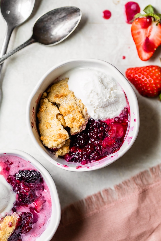 Skillet Mixed Berry Buttermilk Cobbler is made with blackberries, raspberries, and strawberries covered with a delicious biscuit topping and baked in a cast iron skillet.