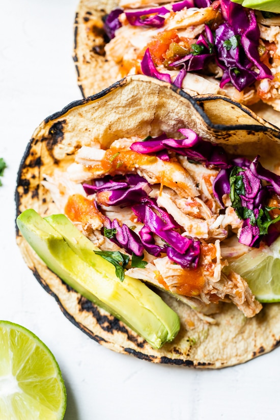 These easy Slow Cooker Chicken Tacos made in the crock pot with chicken breast, salsa, and spices are on repeat in my house!