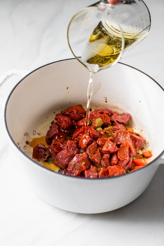 Carne Guisada or Latin Beef Stew is made with chunks of beef simmered in beer with scallions, garlic, tomatoes, cumin and cilantro.