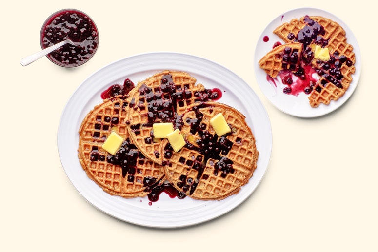 A platter of whole wheat oat waffles with butter and berries