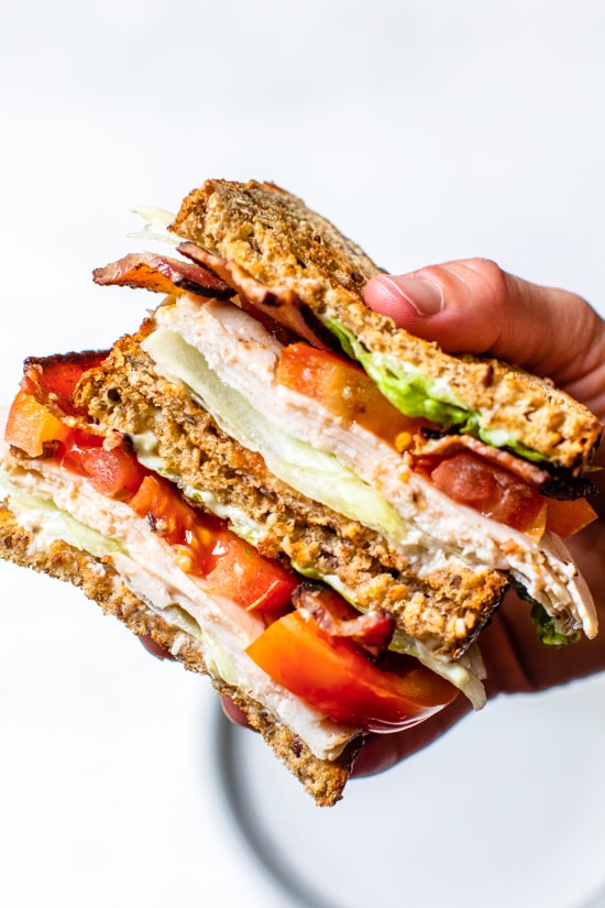 A classic Turkey Club sandwich made healthy, piled high with turkey breast, bacon, lettuce, and tomato on whole grain bread, the perfect easy lunch.