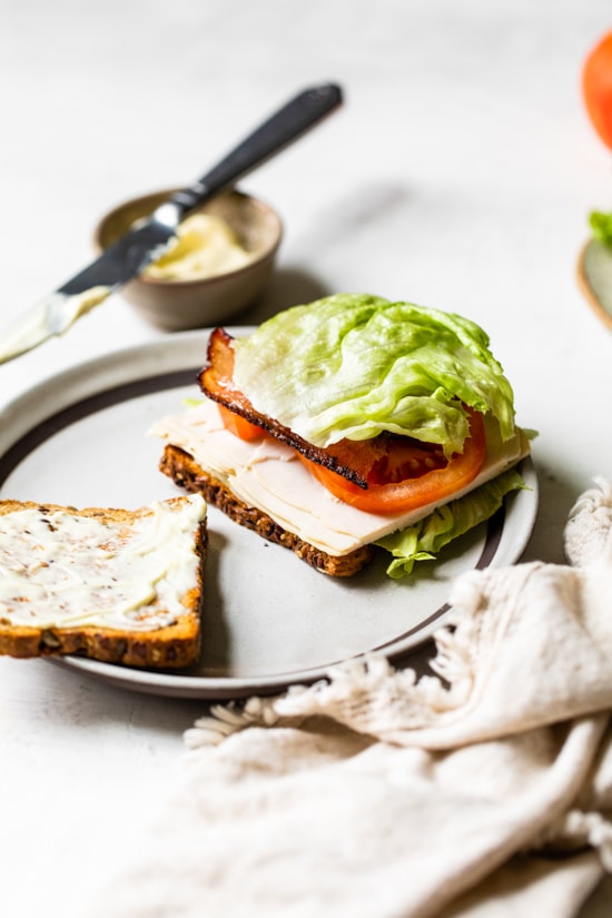 A classic Turkey Club sandwich made healthy, piled high with turkey breast, bacon, lettuce, and tomato on whole grain bread, the perfect easy lunch.