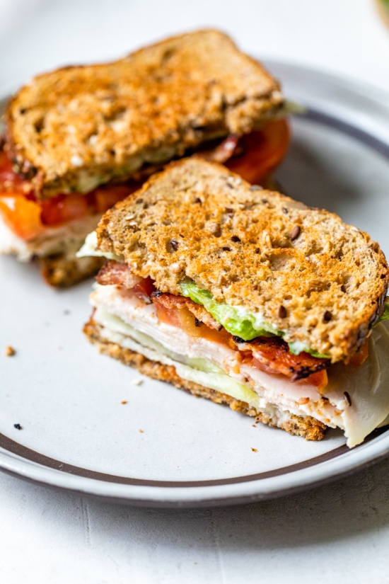 A classic Turkey Club sandwich made healthy, piled high with turkey breast, bacon, lettuce, and tomato on whole grain bread, the perfect easy lunch.