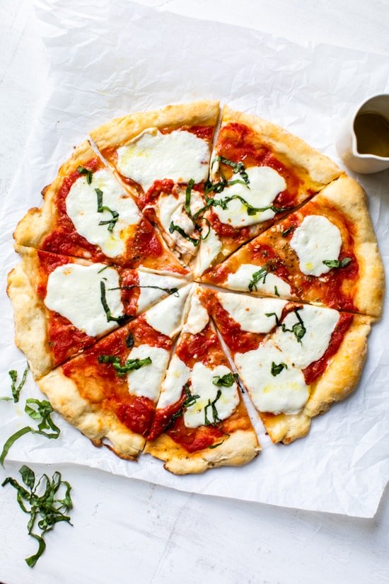 Easy Margherita Pizza made from scratch with my yeast-free, thin crust pizza dough topped with a simple raw tomato sauce, fresh mozzarella cheese, and basil.