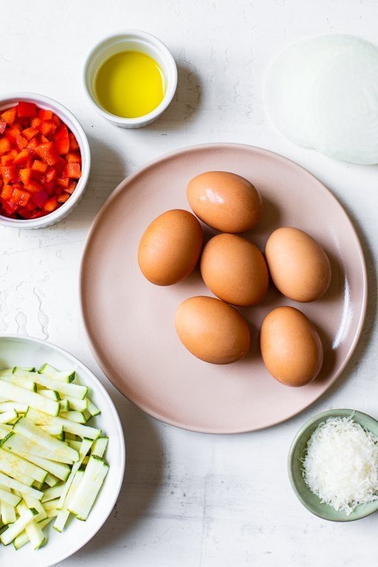 Brown eggs on a plate and vegetables cut up.