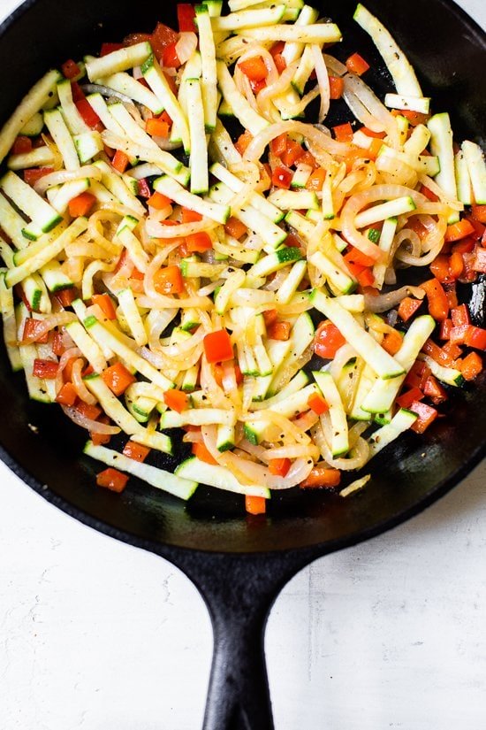 Caramelized Onion Red Pepper and Zucchini in a skillet.